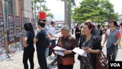 中国大陆游客在香港阅读六四文宣 (美国之音记者申华 拍摄))