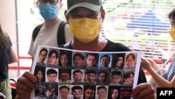 香港民众手举47位泛民派活动人士的照片表示支持。(法新社2021年5月31日)