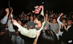 1999年5月8日,在北约误炸中国驻南斯拉夫大使馆之后,北京学生在美国使馆外面焚烧美国国旗