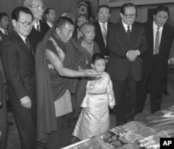 1996年1月12日,中方选择的六岁的11世班禅喇嘛向中国主席江泽民呈现给他的礼品。中国政协主席李瑞环在场。