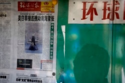 资料照:北京街头一名男子在读一处报栏里张贴的环球时报。 (2016年4月5日)