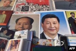 2018年2月26日,北京一个市场陈列的中国国家主席习近平像和前共产党领袖毛泽东像。