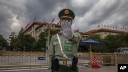资料照:中国武警士兵做出禁止给北京人大会堂拍照的手式 。(2020年5月25日)