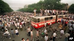 资料照:大批人群在北京一处交叉路口试图用公共汽车和路障拦阻军队向天安门广场推进。(1989年6月3日)
