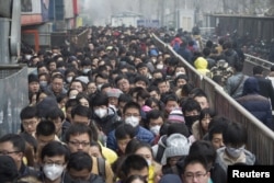 2015年12月8日,在北京首次发布空气污染红色警报后,乘客在地铁站排队。