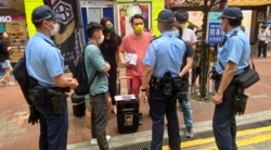 多名军装及便衣警员,截查摆街站反对当局收紧查册安排的工会成员 (美国之音/汤惠芸)