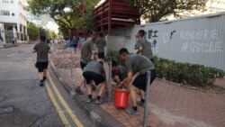 中国驻港部队军人星期六(11月16日)在香港清除抗议活动之后留下的路障和垃圾。