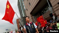资料照:台湾中华统一促进党在台北街头挥舞五星红旗,呼吁加强两岸关系。(2016年5月18日)