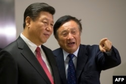 中国国家主席习近平在伦敦访问华为公司的办公室,华为总裁任正非介绍情况(2015年10月21日)。