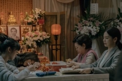 秀英阿嬷与女儿和孙女在灵堂里折纸莲花。(威视电影授权提供)