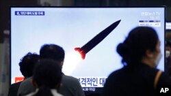 2021年3月25日,在韩国首尔的一个火车站,人们正在观看播放朝鲜发射弹道导弹的电视新闻节目。(美联社)