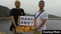 7月17日,大连维权人士姜建军(右)、王承刚前往大连老虎滩海边祭奠刘晓波。(推特图片)
