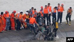 一名幸存者(绿色上衣)被潜水员从“东方之星”客轮残骸中救出。(2015年6月2日)