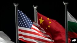 资料照:2022年冬奥会开幕前,美国和中国国旗在中国张家口的云顶滑雪公园飘扬。(美联社)