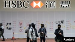 携带枪支的香港便衣警察守卫着汇丰银行在香港元旦大游行期间遭到遭到破坏的湾仔分行。(2020年1月1日)