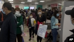 2023 年 10 月 30 日,北京一家儿童医院的家长带着孩子在拥挤的候诊室里等待。中国各地呼吸道疾病激增,引起了世界卫生组织的关注。