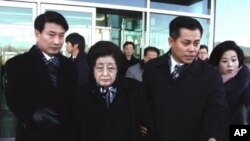 12月26号,韩国前总统金大中的遗孀李姬镐(中)和吊唁团中的其他成员抵达北韩