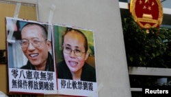 2017年6月27日,一些人在香港中联办外面示威,举着刘晓波夫妇的照片。