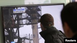 2012年12月12日,在韩国首尔火车站,人们观看电视播放朝鲜发射远程火箭的画面
