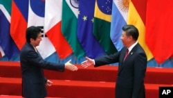 日本首相安倍晋三和中国国家主席习近平在中国杭州举行的20国集团峰会上握手。(2016年9月4日)