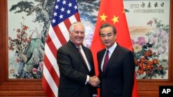 美国国务卿蒂勒森(左)与中国外交部长王毅(右)在人民大会堂会面前握手。(2017年9月30日)
