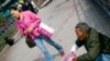 中国广州,一位女士从一个乞丐前面漠然走过。