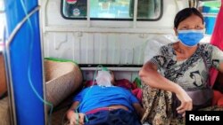 A relative sits with a coronavirus (COVID-19) patient