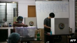 အောက်တိုဘာ ၂၉ ရက်နေ့က ကြိုတင်မဲပေးနေကြသည့် စေတနာ့ဝန်ထမ်းများ ။