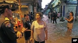 洪水涌入曼谷市中心,居民与警察交谈