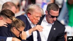 Ứng cử viên tổng thống của Đảng Cộng hòa, cựu Tổng thống Donald Trump, được dìu khỏi sân khấu tại một sự kiện tranh cử ở Butler, bang Pennsylvania, ngày 13 tháng 7 năm 2024.