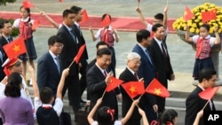 中国国家主席习近平和越南共产党总书记阮富仲前往参加会谈,向欢迎群众招手(2017年11月12日)