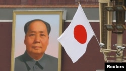 资料照:天安门城楼上毛泽东画像旁飘扬的日本国旗。(2018年10月25日)