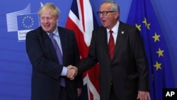 英国首相约翰逊与欧盟委员会主席容克在布鲁塞尔的欧盟总部握手。(2019年10月17日)