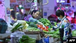 2021年11月1日,中国广西南宁某菜市场一位顾客在购买蔬菜。