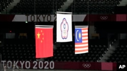东京奥运会羽毛球男双颁奖台上,台湾选手李洋与王齐麟获金牌,中国选手李俊慧与刘雨辰获银牌,马来西亚选手获铜牌。(2021年7月31日)