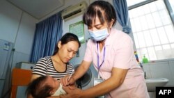 2018年7月23日在中国广西荣安的一家医院,一名儿童接种疫苗。