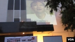 中领馆墙上放映李旺阳香港媒体访问录象 (美国之音容易)