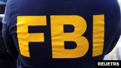 资料照片:一名美国联邦调查局探员制服上的FBI字样 (路透社,2021年10月19日)