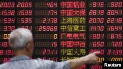 一名上海股民在一处证券交易地点观看电子屏幕显示的股市行情 (2015年6月30日)