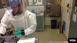 资料照片:病毒学专家斯宾塞·斯通尼尔在位于马里兰德特里克堡的陆军传染病医学研究院的生物安全四级实验室中处理埃博拉样本。(2014 年12月11日)