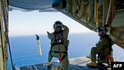 澳大利亚皇家空军人员在印度洋南部海域上空准备从C-130飞机上投放自定位数据标志浮标。(2014年3月20日)