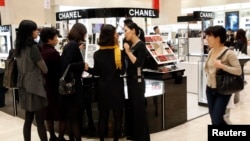 顾客在韩国首尔新世界百货商店化妆品柜台前挑选物品。(资料照)