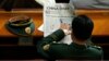 Một đại biểu quân đội đọc tờ China Daily trước phiên họp toàn thể lần thứ hai của Đại hội đại biểu Nhân dân toàn quốc (Trung Quốc) tại Bắc Kinh, ngày 9/3/2009. (REUTERS/David Gray)