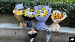 武汉民众在武汉中心医院摆放鲜花悼念新冠病毒“吹哨人”李文亮逝世一周年。(美联社提供)