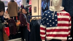 一名女子在美国零售商Gap北京旗舰店试穿毛衣。中美贸易谈判的不确定性给亚洲市场蒙上了一层阴影,双方都对未来保持沉默。(2019年1月10日)
