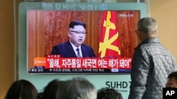 在首尔火车站,韩国人观看朝鲜领导人金正恩的电视新年讲话(2017年1月1日)