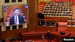 资料照:2019年中国政协会议开幕时,会场屏幕显示中国领导人习近平出席会议的图像