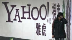 资料照片:一名女子在北京地铁里走过雅虎广告牌。(2006年3月17日)
