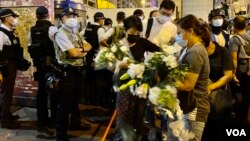 立法会议员毛孟静(戴黑口罩者)8月31日晚在太子地铁站出口外协助市民献花纪念8-31事件一周年。 (美国之音/汤惠芸)