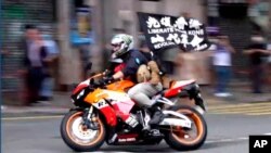 2020年7月1日唐英杰驾车时展示“光复香港,时代革命”的旗帜。